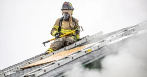 Firefighter using forcible entry tools at a building entrance